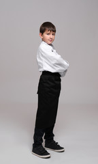 Fototapeta na wymiar Cute boy in chef uniform on light background