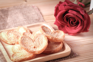 Paddle a butterfly, heart shaped patty crispy with sugar in a wooden plate , The concept of Valentine's Day.