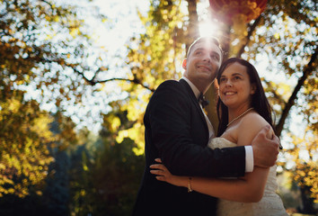 Fototapeta premium Happy newlyweds and a bright sunlight in the park