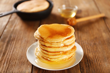 Fototapeta na wymiar Delicious pancakes with maple syrup on wooden table
