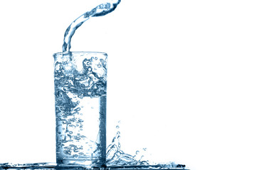 Water splashing into glass quickly feels refreshing on white background.