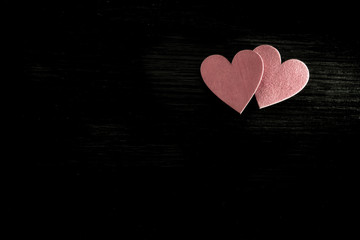 Two red hearts lie on the wooden background 