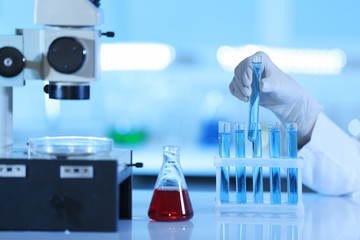 Scientist putting test tube on holder