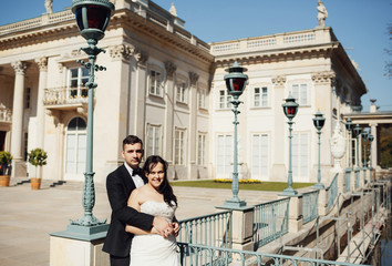 Fototapeta premium Newlyweds on the bridge and a beautiful castle behind