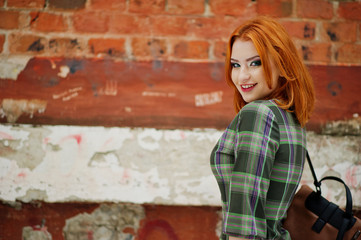 An outdoor portrait of a young pretty girl with red hair wearing