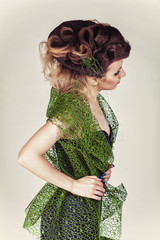 Beautiful Fashion Model with Big Hairstyle in green mesh and blue dress. Woman with long blue nails