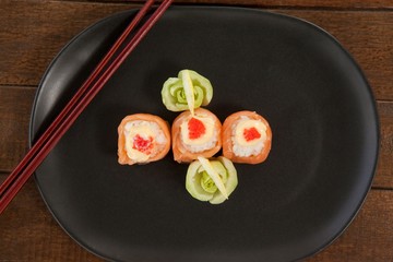 Three nigiri sushi served in black plate with chopsticks