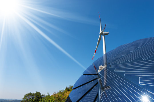 Solar panel and a wind turbine on a clear blue sky - Green energy concept