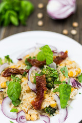 Fresh Vegetable Meal Detail on White Plate. Onion, Chickpea Basil Leaves and Dry Tomatoes Salad with Raw Ingredients on Wooden Background.