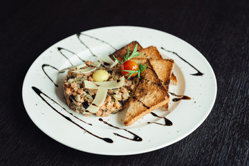 Salad with croutons and quail egg on a white plate
