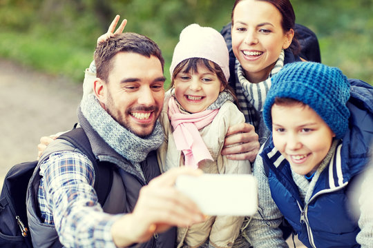 family taking selfie with smartphone in woods