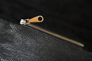 Gold zipper on the background of skin and nubuck