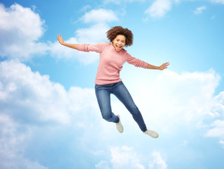 happy african american woman jumping over white