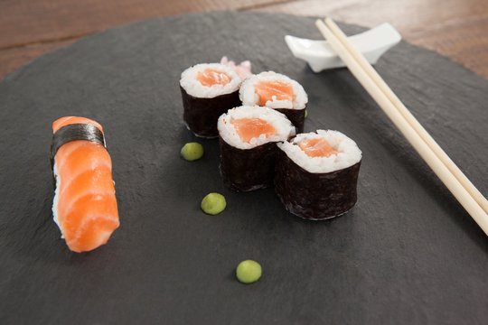 Set of assorted sushi served with chopsticks on grey stone slate
