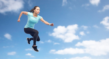 Fototapeta premium happy sporty young woman jumping in air