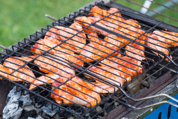 Grilling chicken wings on barbecue grill.