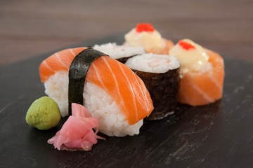 Nigiri and uramaki sushi served on black stone