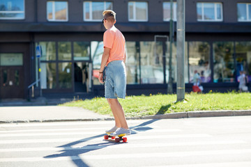 teenage boy on skateboard crossing city crosswalk