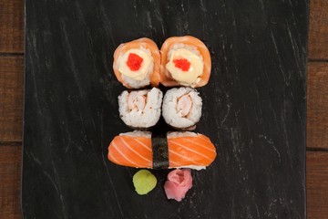 Nigiri and uramaki sushi served on black stone