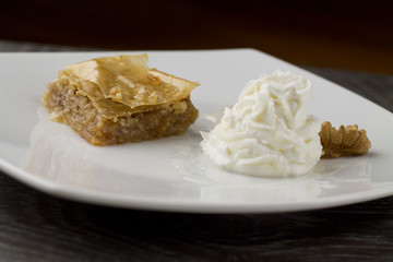 baklava close up served with greek yogurt, dark background