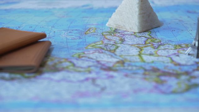 Foreign passports and souvenirs from summer vacation on map, travel by car