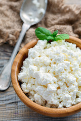 Wooden bowl with cottage cheese and mint.