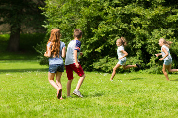 Obraz premium group of happy kids or friends playing outdoors