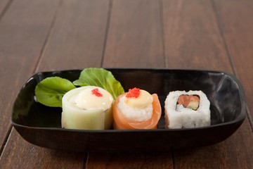 Nigiri and uramaki sushi served on black boat plate