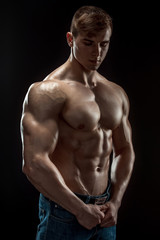 Young bodybuilder man on black background