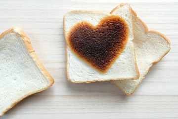 bread with heart shape burn on wooden table