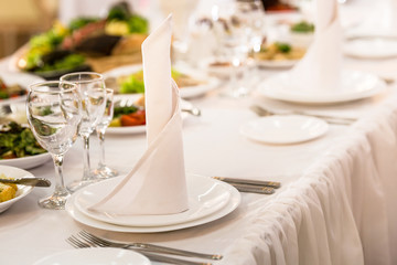 White tablecloth and restaurant cutlery, dish, plate, glass. Served table