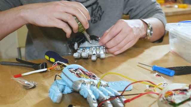 Scientist assembling innovative cybernetic robotic arm. Hi-tech innovative technology. 4K.