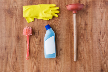 plunger with cleaning stuff on wooden background