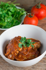 Chicken with sauce tomato in white bowl.