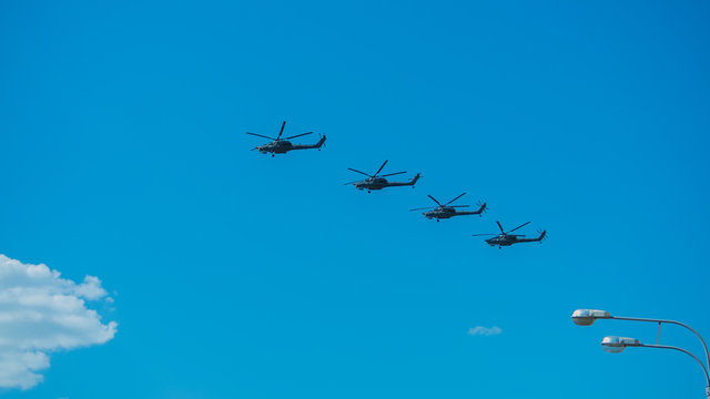Four combat helicopters flying over the city
