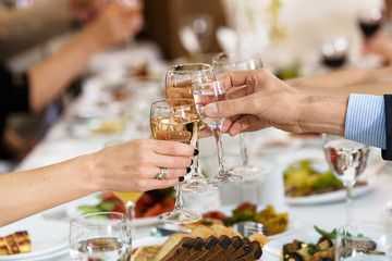 group of people in banquet hall toasting. Toasting glasses