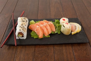 Uramaki, sashimi and nigiri sushi served with chopsticks