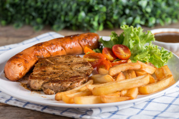 Steak with sausage and french fries.