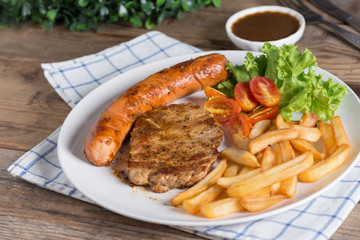 Steak with sausage and french fries.
