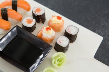 Various sushi on tray with sauce
