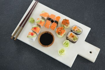 Various sushi on tray with sauce