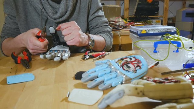 Man assembling innovative cybernetic bionic arm. Hi-tech innovative prosthetics. 4K.