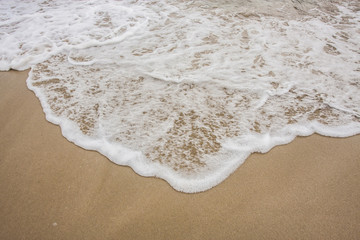 Foamy wave on a beach