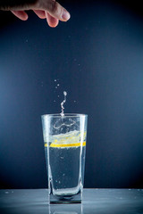 Glass glass of water with lemon on the isolated background. Mountain ineralnaya pure mountain water with gas bubbles and a lemon slice and spray tonic refreshing sports drink.