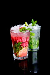 cold drink with mint and raspberries on black background