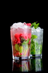 cold drink with mint and raspberries on black background