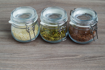 Collection of sesame seeds, flax seeds, pumpkin seeds in glass jar