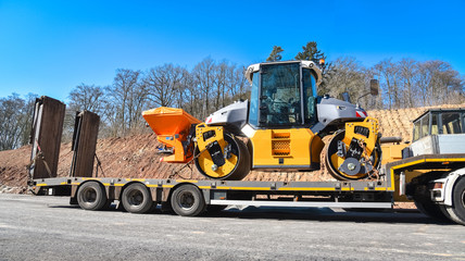 Straßenbau - Straßenwalze auf einem Tieflader