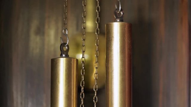 the movement of the pendulum and the weights of old wooden clock