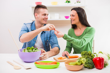 Young couple cooking in their kitchen.